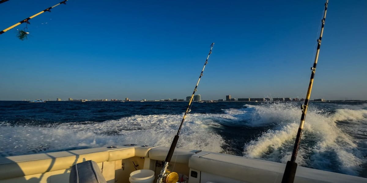 A fishing boat cruising on open water with fishing rods in view, emphasizing the need to know when to file a boating accident report while enjoying water activities