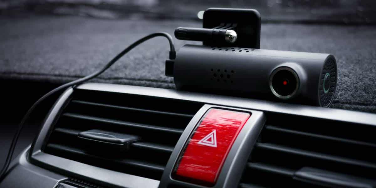 A device is positioned to capture dash cam footage from the front view of the cars interior.