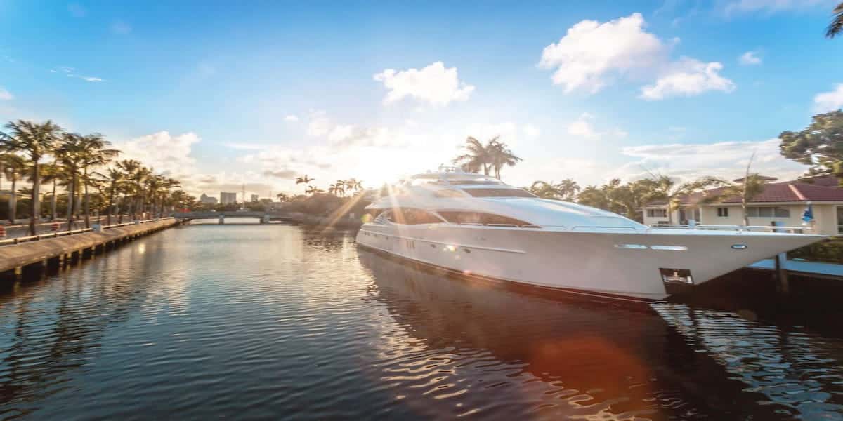 A luxurious yacht docked along a serene Florida canal at sunset, highlighting the importance of Florida life jacket laws for boaters enjoying the state's beautiful waterways.