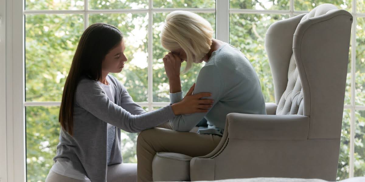 A grieving woman being comforted by another, illustrating the emotional toll of proving wrongful death in legal cases.