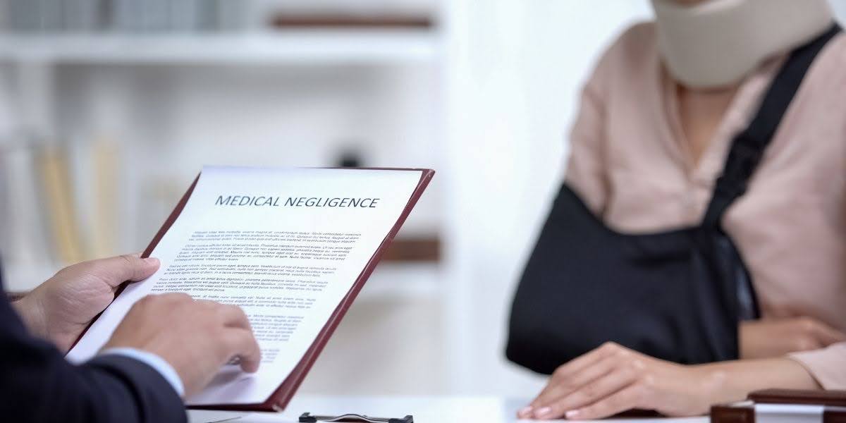 A lawyer reviewing a medical negligence claim document with an injured patient wearing a neck brace and arm sling, representing legal action for malpractice.