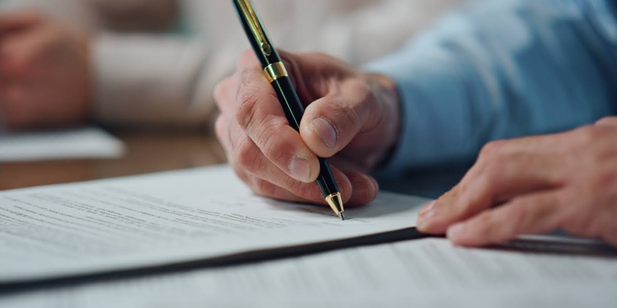 A close-up of a hand signing legal documents, symbolizing the process of securing wrongful death settlements for families seeking compensation.