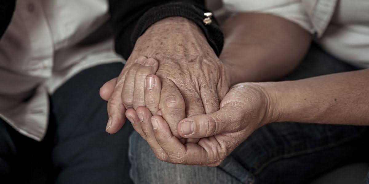 Close-up of two people holding hands in a comforting gesture, symbolizing support and legal guidance in a wrongful death statute of limitations case.